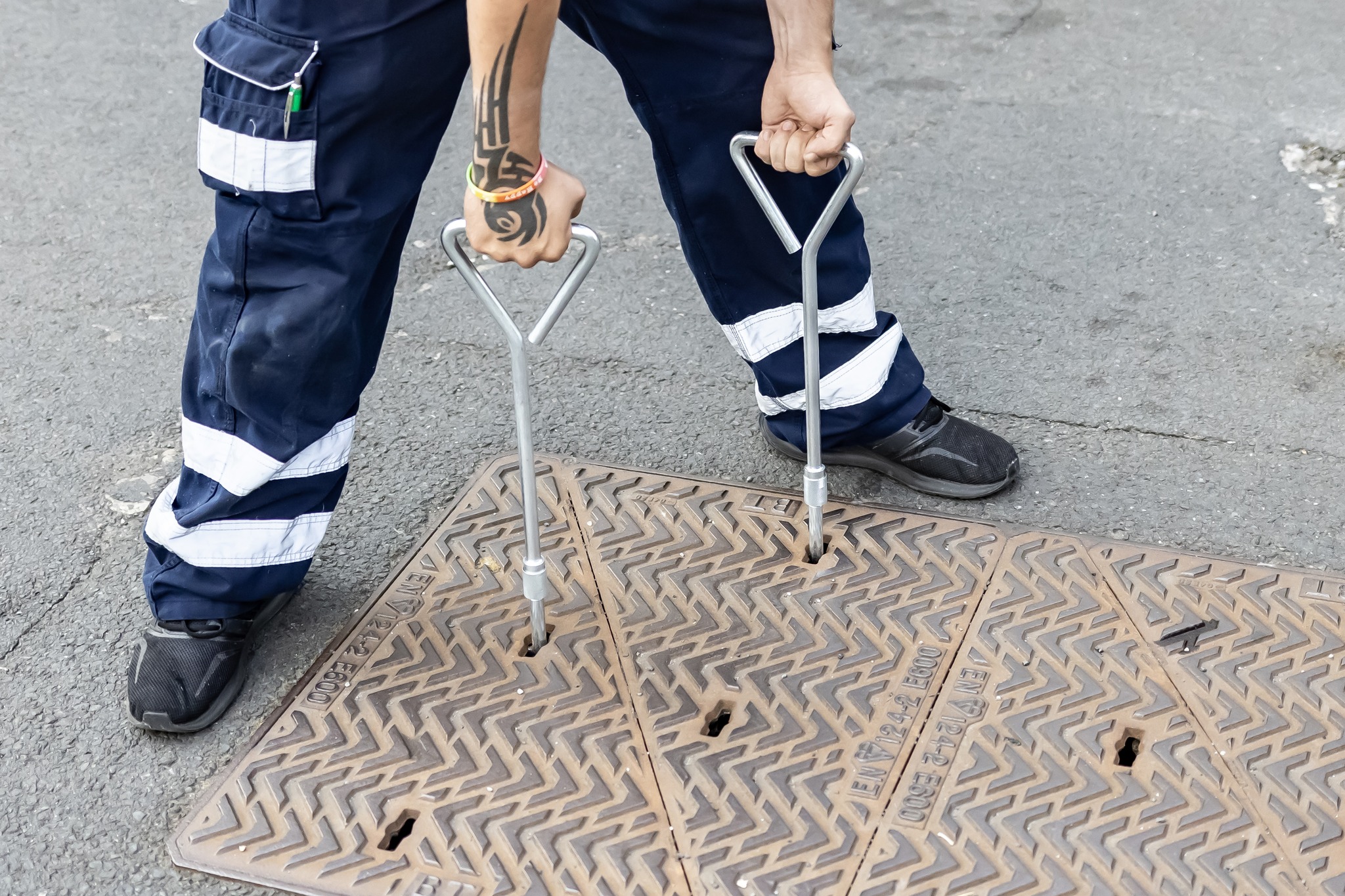 A drain with someone removing the cover