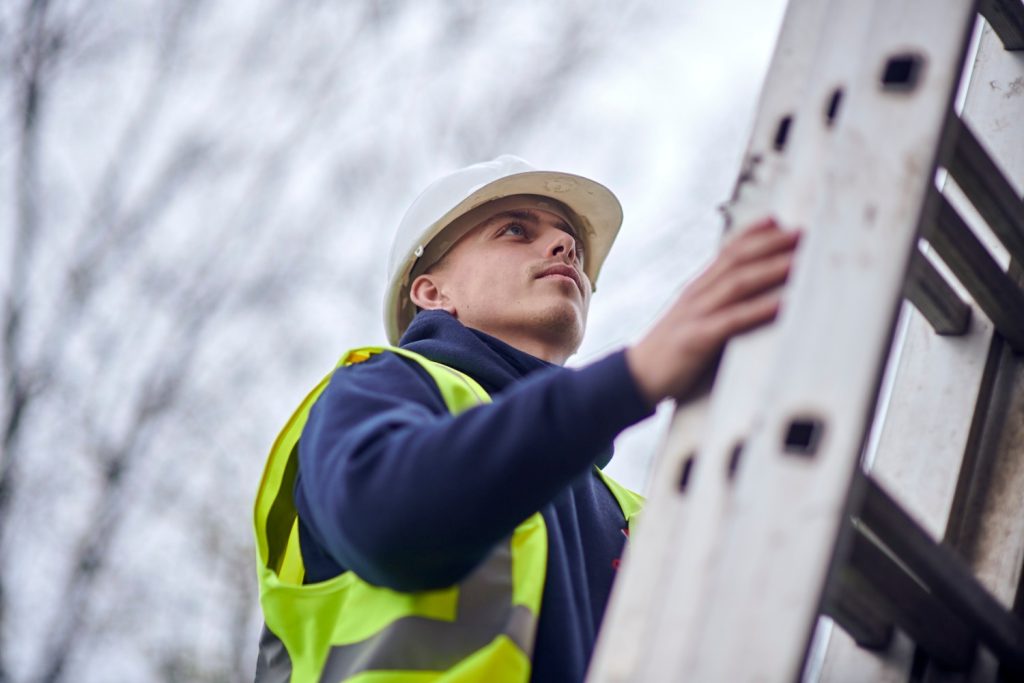 A bird netting technician on a ladder